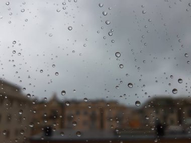 Cenova, İtalya - 11 / 28 / 2019: İnanılmaz renkli bir gökyüzü ve bir parça güneş ışığı ile çok şiddetli bir yağmurdan sonra pencerenin üzerindeki su damlasının inanılmaz bir başlığı. Takasın makro fotoğrafçılığı.