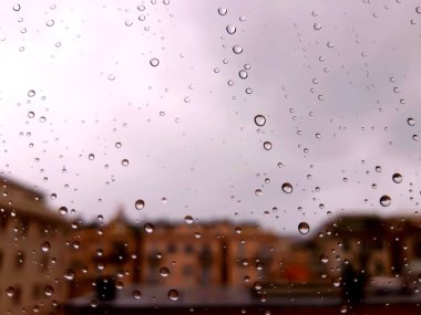 Cenova, İtalya - 11 / 28 / 2019: İnanılmaz renkli bir gökyüzü ve bir parça güneş ışığı ile çok şiddetli bir yağmurdan sonra pencerenin üzerindeki su damlasının inanılmaz bir başlığı. Takasın makro fotoğrafçılığı.