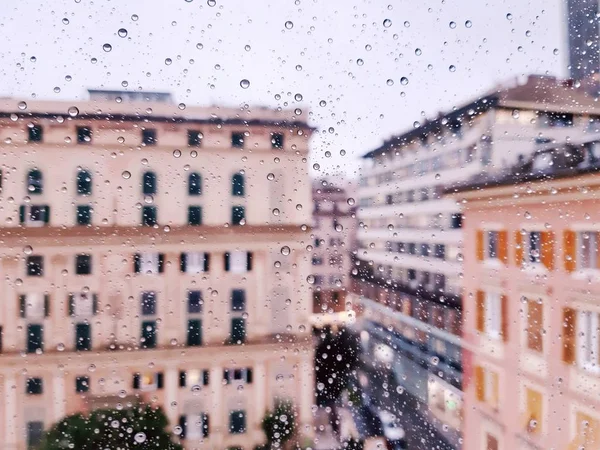 Genova, Italy - 11/28/2019: An amazing caption of the waterdrop over the window after very strong rain with an incredible coloured sky and a piece of sunshine. Macro photography of the drop.