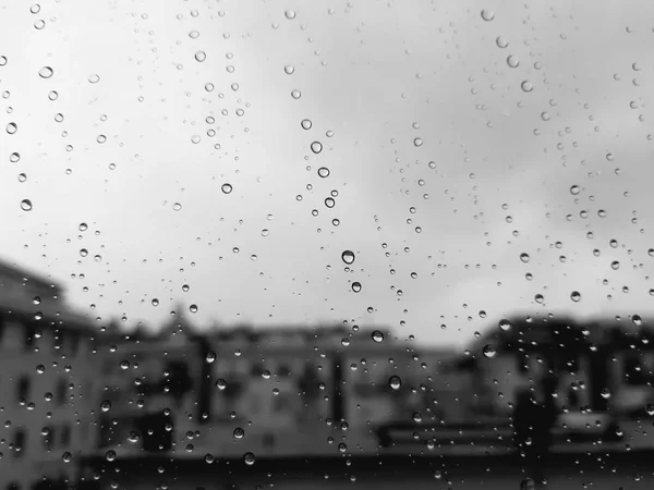 Genova, Italy - 11/28/2019: An amazing caption of the waterdrop over the window after very strong rain with an incredible coloured sky and a piece of sunshine. Macro photography of the drop.