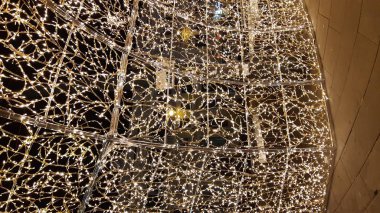 Cenova, İtalya - 12 / 10 / 2019: Cenova sokaklarında kış aylarında sanatsal bir geçmişe sahip muhteşem bir Noel süslemesi ışıkları ve o anı birleştiren bazı insanlar