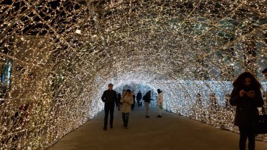 Cenova, İtalya - 12 / 10 / 2019: Cenova sokaklarında kış aylarında sanatsal bir geçmişe sahip muhteşem bir Noel süslemesi ışıkları ve o anı birleştiren bazı insanlar