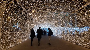 Cenova, İtalya - 12 / 10 / 2019: Cenova sokaklarında kış aylarında sanatsal bir geçmişe sahip muhteşem bir Noel süslemesi ışıkları ve o anı birleştiren bazı insanlar