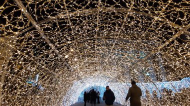 Cenova, İtalya - 12 / 10 / 2019: Cenova sokaklarında kış aylarında sanatsal bir geçmişe sahip muhteşem bir Noel süslemesi ışıkları ve o anı birleştiren bazı insanlar