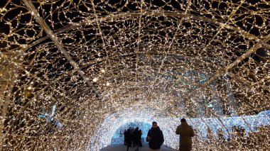 Cenova, İtalya - 12 / 10 / 2019: Cenova sokaklarında kış aylarında sanatsal bir geçmişe sahip muhteşem bir Noel süslemesi ışıkları ve o anı birleştiren bazı insanlar