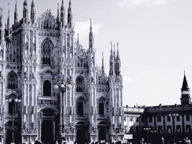 Milan, İtalya - 12 / 25 / 2019: Milano Duomo 'sunun kış günlerindeki muhteşem bir manşeti, bazı insanların akşamın tadını çıkardığı, güzel siyah beyaz arka plan ve bazı ufuk çizgilerinin güzel fotoğrafı
