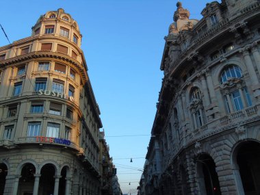 Cenova, İtalya - 01 / 07 / 2020: Güzel kış gününde Ceneviz 'in şehir merkezine dönün. Şehrin eski mimarisine inanılmaz bir manzara. Arka planda mavi gökyüzü ve şehrin üzerinde ay var..