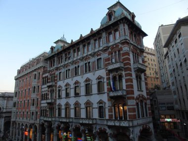 Cenova, İtalya - 01 / 07 / 2020: Güzel kış gününde Ceneviz 'in şehir merkezine dönün. Şehrin eski mimarisine inanılmaz bir manzara. Arka planda mavi gökyüzü ve şehrin üzerinde ay var..