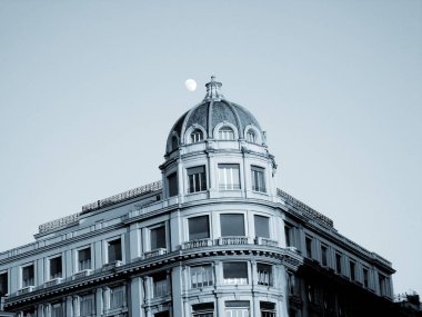 Cenova, İtalya - 01 / 22 / 2020: Ceneviz şehir merkezine güzel bir kış günü panoramik manzara. Arka planda mavi gökyüzü ve şehrin üzerinde ay olan eski mimariye inanılmaz bir bakış açısı..