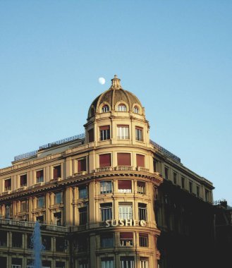 Cenova, İtalya - 01 / 22 / 2020: Ceneviz şehir merkezine güzel bir kış günü panoramik manzara. Arka planda mavi gökyüzü ve şehrin üzerinde ay olan eski mimariye inanılmaz bir bakış açısı..