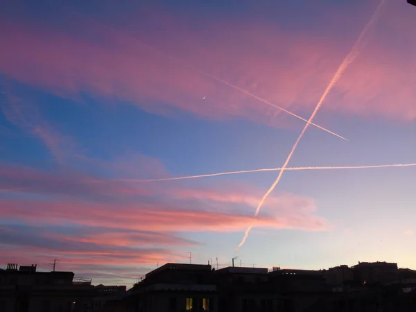 Genova Italy 2020 美しい赤い空といくつかの素晴らしい雲と背景に小さな月明かりでジェノヴァの街の冬の日の夕日の素晴らしいキャプション — ストック写真