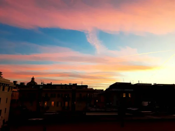 Genova Italy 2020 美しい赤い空といくつかの素晴らしい雲と背景に小さな月明かりでジェノヴァの街の冬の日の夕日の素晴らしいキャプション — ストック写真