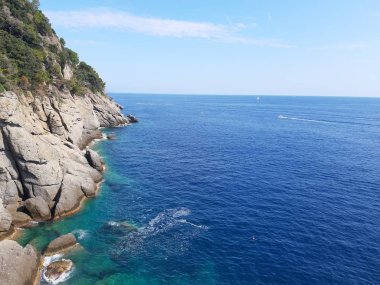 Liguria, İtalya ve Avrupa 'da büyük dalgaların kıyıya vurduğu yakın çekim. Denizin beyaz dalgaları kayalıklarda kopuyor.