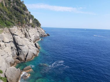 Liguria, İtalya ve Avrupa 'da büyük dalgaların kıyıya vurduğu yakın çekim. Denizin beyaz dalgaları kayalıklarda kopuyor.