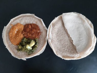 Asmara, Eritrea - 05/08/2020: Ethiopian and Eritrean food, assortment of main dishes. Injera is a sourdough flatbread made from teff flour. It is the national dish of Ethiopia, Eritrea. clipart