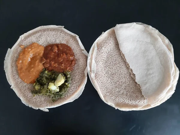 Asmara, Eritre - 05 / 08 / 2020: Etiyopya ve Eritre yemekleri, çeşitli ana yemekler. Injera, Teff unundan yapılmış bir ekşi hamurlu ekmek. Etiyopya 'nın ulusal yemeği, Eritre..