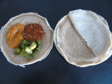 Asmara, Eritre - 08 / 05 / 2020: Etiyopya ve Eritre yemekleri, çeşitli ana yemekler. Injera, Teff unundan yapılmış bir ekşi hamurlu ekmek. Etiyopya 'nın ulusal yemeği, Eritre..
