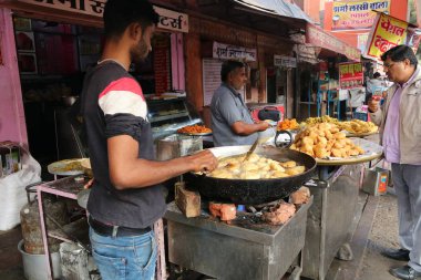 Jaipur, Rajasthan / Hindistan - Aralık 07: 2019: Jaipur 'da sokak yemekleri. Adam sokak kafesinde geleneksel Hint yemekleri alıyor.