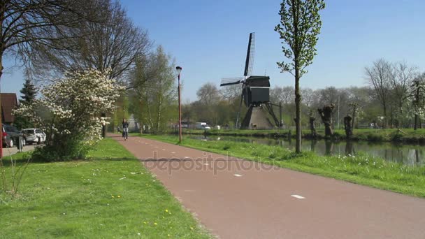 Fietsers met windmolen — Stockvideo