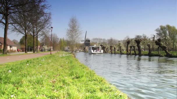 Boot auf Kanal mit Windmühle — Stockvideo