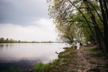 Nehir kenarındaki Boho tarzında bir düğün töreni için kemer ve dekor.