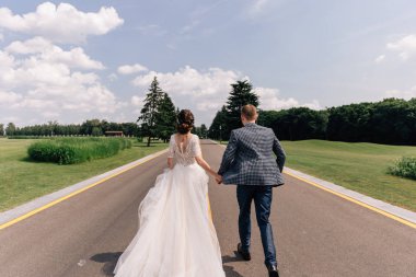 Gelin ve damat yol boyunca koşuyorlar.