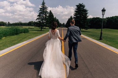 Gelin ve damat yol boyunca koşuyorlar.