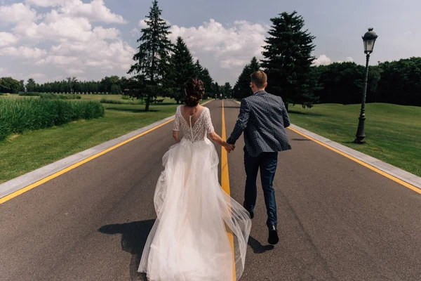 Gelin ve damat yol boyunca koşuyorlar.