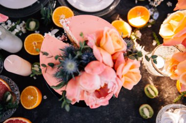 Mercanda taze çiçeklerle süslenmiş düğün pastası.