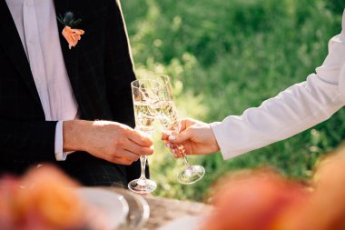 Gelin ve damat sokaktaki bir masada kadeh tokuşturuyorlar.