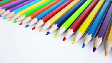 Sonu gelmeyen sayısız renkli kalemlerin yakın görüntüsü. Beyaz arkaplanda düzenlenmiş sanatsal renkli kalemlere odaklı kamera. Yaratıcılık fikri. 3d 60 fps kusursuz döngü animasyonu.