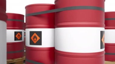 Ahşap paletlerin üzerinde sonsuz sıra dizilmiş yanıcı sembollü kırmızı metal varillere yakın çekim. Ön planda paletli yakıt varillerinin yeniden odaklanmış görüntüsü var. 60 fps pürüzsüz döngü animasyonu.