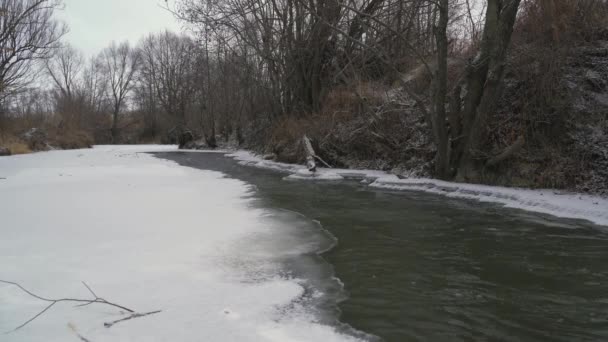 Ghiaccio e neve sul fiume, acqua che scorre — Video Stock