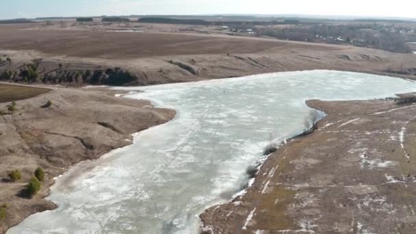 Herbe sous la neige. Rivière gelée dans le champ 