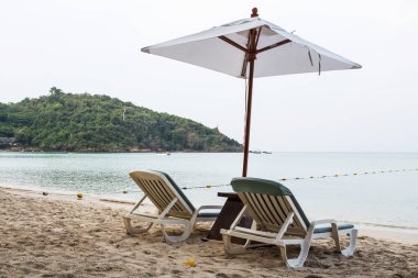 Tayland 'da güzel bir adada güneş şemsiyeleri ve plaj sandalyeleri.