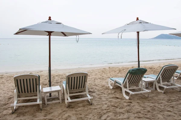 Vista su due ombrelloni bianchi con sdraio sulla spiaggia — Foto Stock