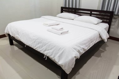 Beyaz yatak ve yastık otel odasında.