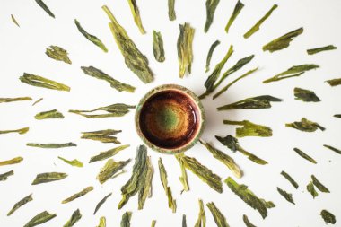 çevresinde kil kase üstten görünüm beyaz yüzeyi ile yeşil kurutulmuş bitki yaprakları