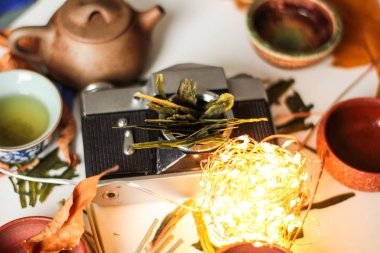 eski moda fotoğraf kamera gövdesi, tablo ile ışıklı çelenk ışık ve Asya çaydanlık seti bitkisel yaprakları kuru