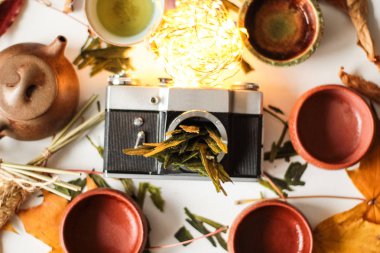 Asya çaydanlık üst görünümü ayarlama ve eski moda fotoğraf kamera vücudun içine kuru bitkisel bırakır