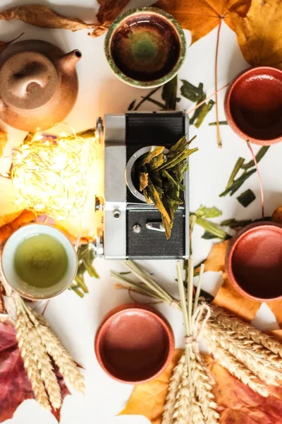 Asya çaydanlık üst görünümü ayarlama ve eski moda fotoğraf kamera vücudun içine kuru bitkisel bırakır