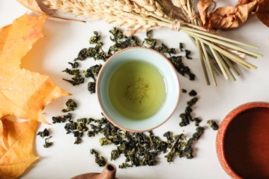 çay bardağı Üstten Görünüm tablo sonbahar akçaağaç yaprakları ve yeşil çay yaprakları kurutulur