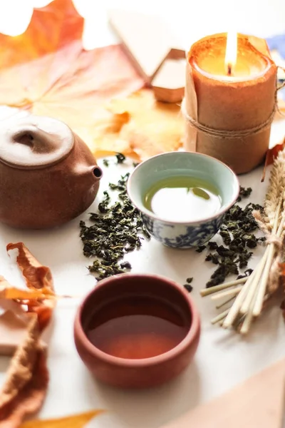 烧蜡烛和绿茶仪式在桌上与茶壶和秋天叶子 — 图库照片