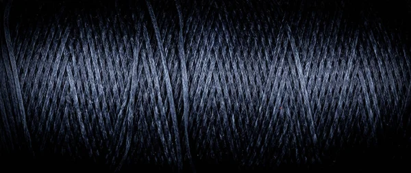 close up of twisted blue black color thread, horizontal macro background