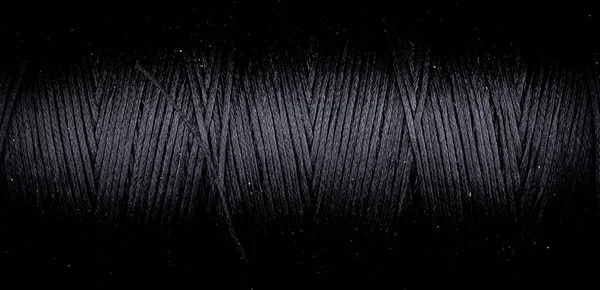 close up of twisted black colored thread, horizontal macro background