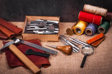 Tablo Tekstil, deri tekne ekipmanları, demir cetvel, çekiç ve Büyüteç camı kabartma ile kaplı