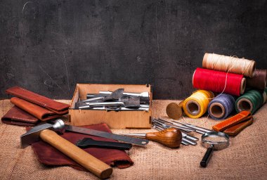 Tablo Tekstil, deri tekne ekipmanları, demir cetvel, çekiç ve Büyüteç camı kabartma ile kaplı