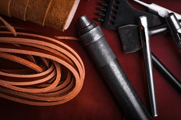 close up of handcraft leather tools set and rolled leather fabric with straps