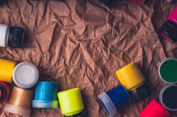 kraft paper surface with colorful fabric paint bottles 