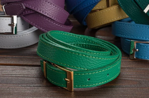 close up shot of rolled female belts, green genuine leather female belt demonstration